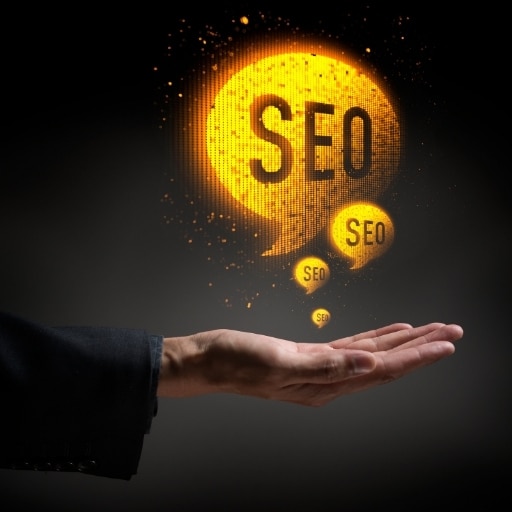 Hand holding glowing SEO speech bubbles, symbolizes the importance and power of SEO in digital marketing strategy.